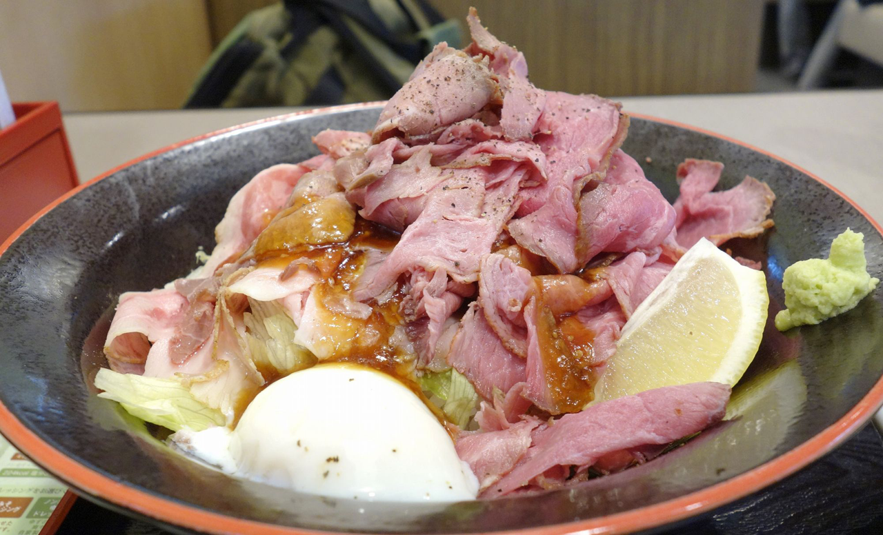 「特盛り炙りローストビーフ丼」は、バラ肉と赤身もも肉をたっぷり山のように敷き詰めたどんぶり飯で、特盛りの名にふさわしいボリューム感！