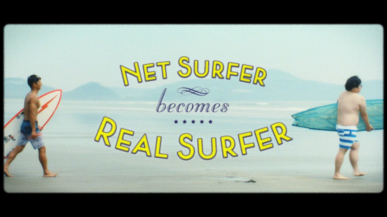 宮崎県日向市のPR動画「Net surfer becomes Real surfer」オープニングのひとコマ。右側が変貌前の道仙拓真さん、左はサーフィン師匠の松本哲也さん