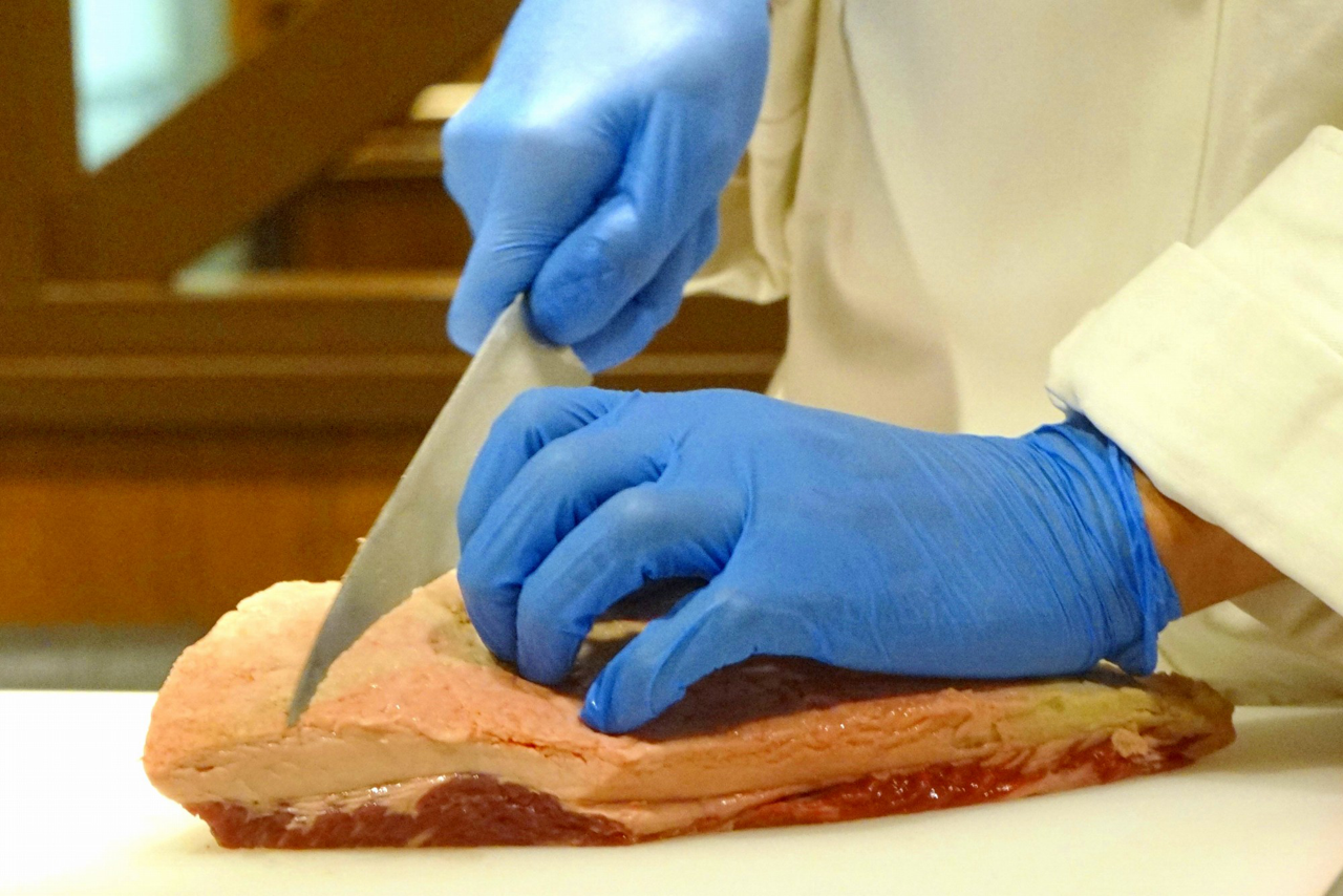 まずは塊肉からステーキサイズにお肉を手切り実演からスタート！　まずは、任意のグラム数に見合った厚さにお肉を切り出します