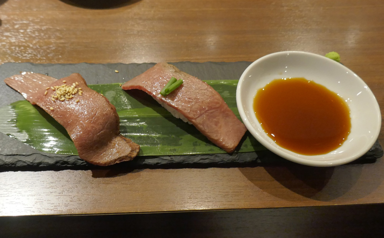 今回注文した肉寿司は、左手がごまを乗せた「あぶり寿司　赤身」、右手にネギを乗せた「あぶり寿司　白身」が盛り付けられています