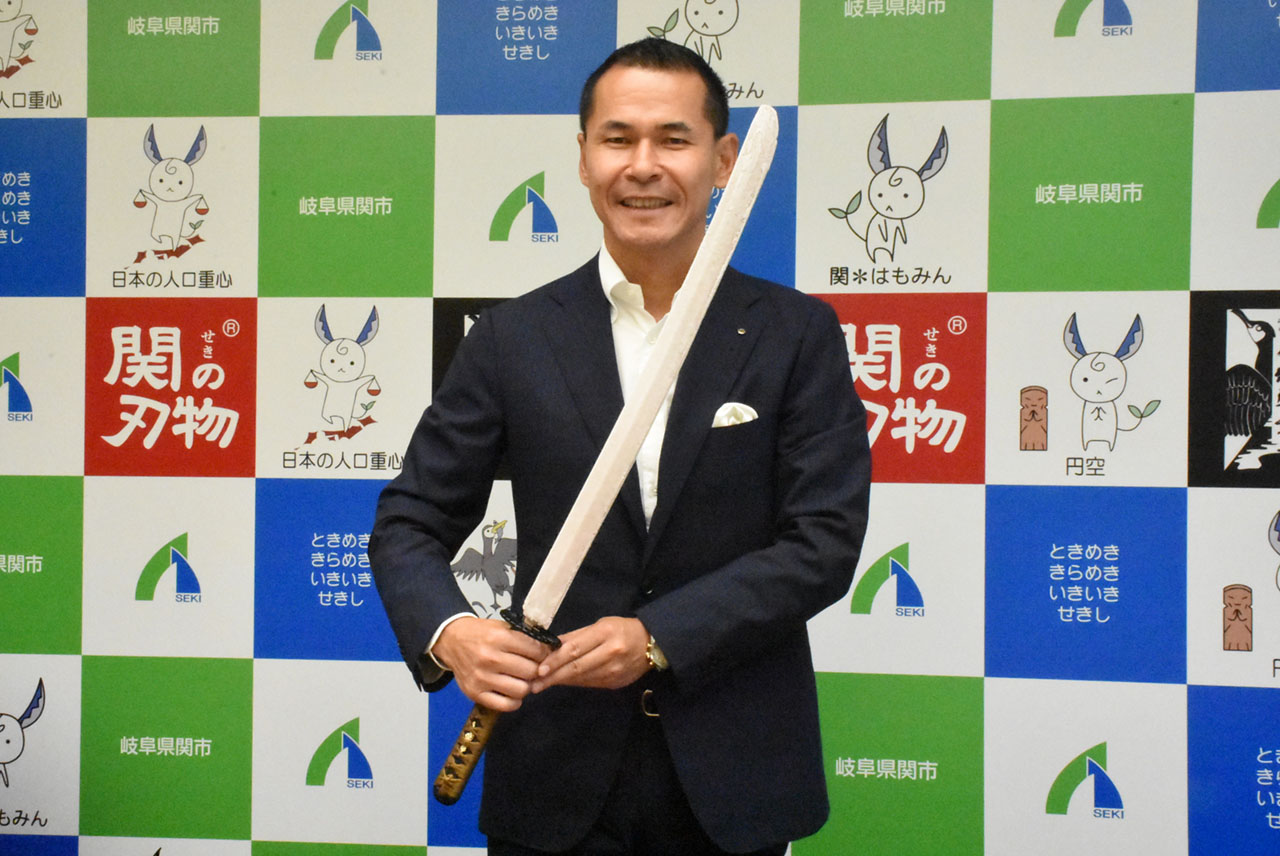 日本刀アイス「あずきバー」の試作品を手にする尾関健治市長