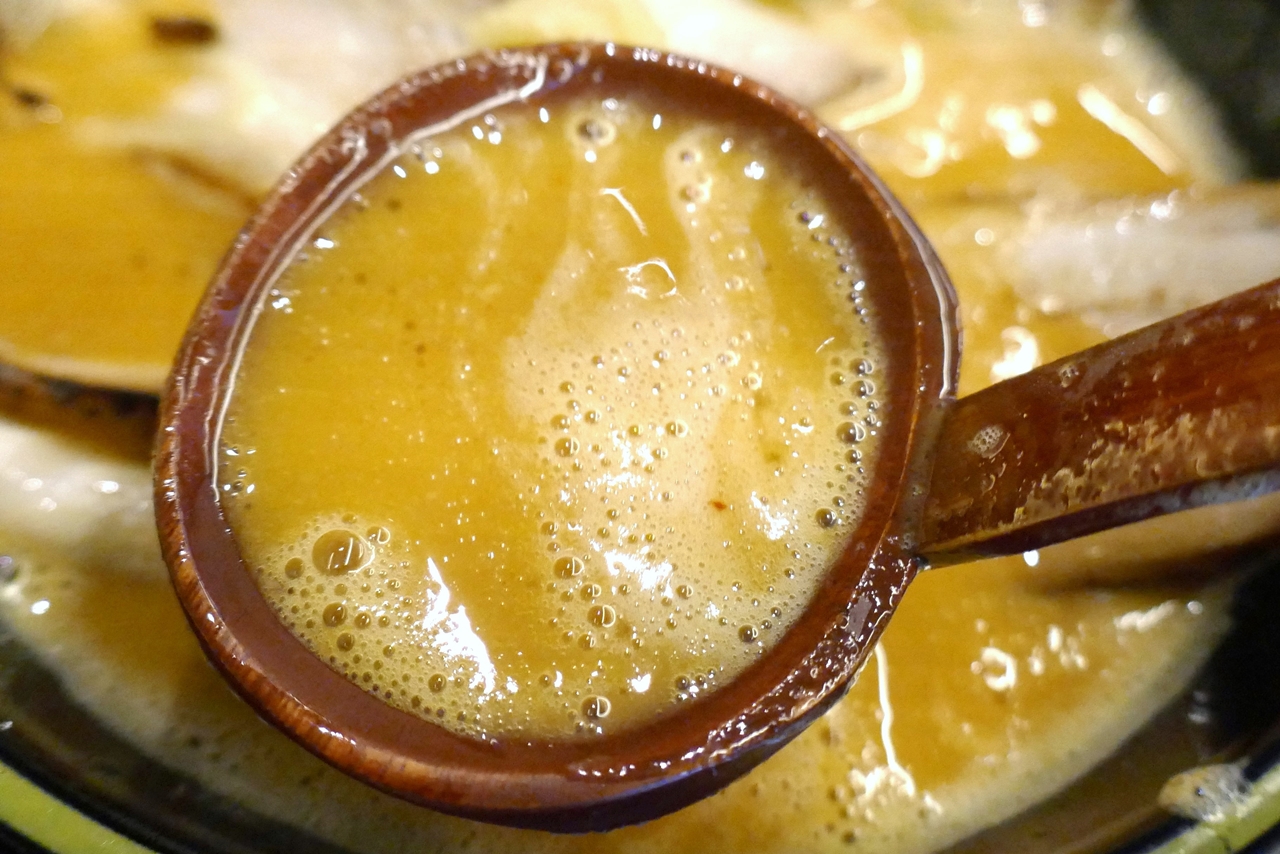 豚骨スープの風味、ニンニク、唐辛子の風味がバランスよく感じられながらも塩気がマイルドなのが海外のラーメン店っぽい、オレンジ色のスープ