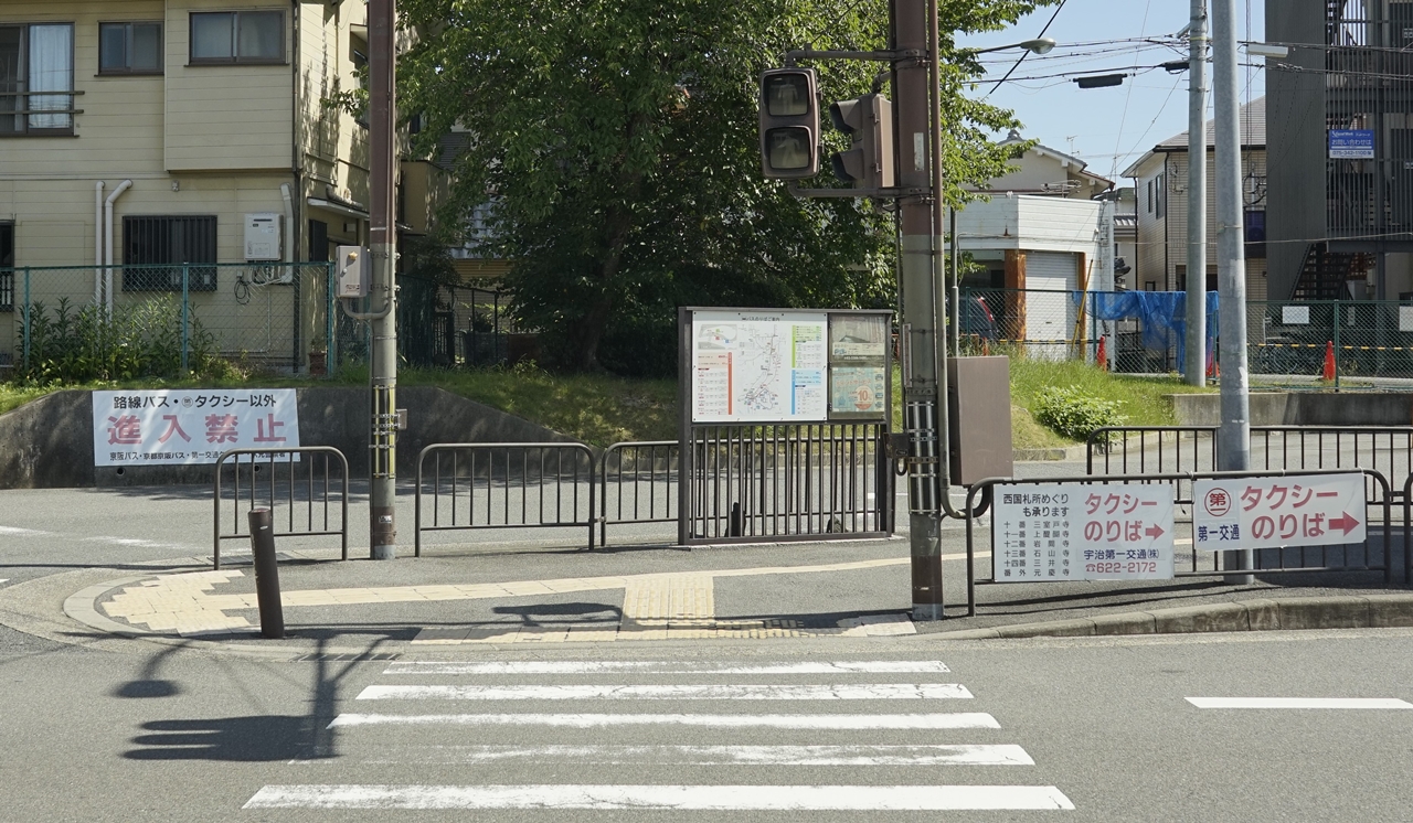 「六地蔵駅（京阪宇治線）」出入口から正面横断歩道を見たシーンは1話「ようこそハイスクール」に登場
