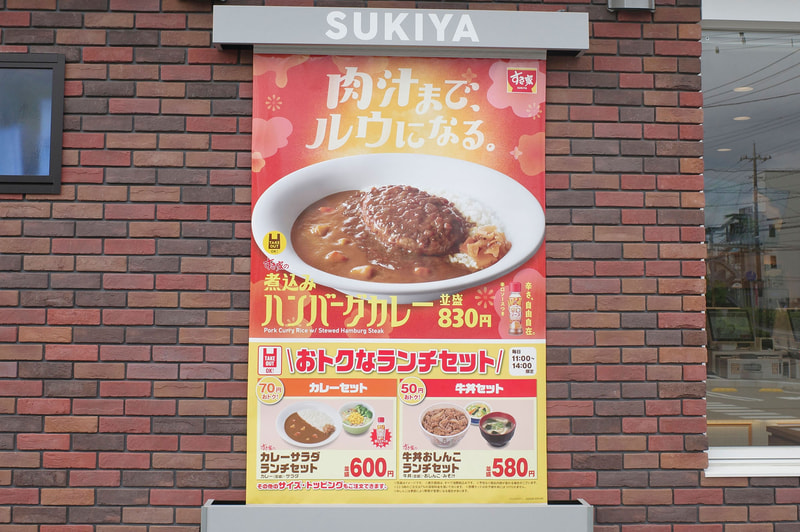 店舗入口左手に「煮込みハンバーグカレー」と「おトクなランチセット」の存在を告知する巨大ポスターを発見！