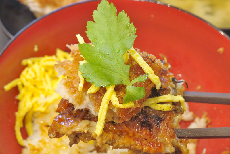 「うなかつ丼」としてほおばることで、ロースかつのジューシー感、うなぎの蒲焼きの味の濃さが海苔、錦糸玉子、ご飯と一体となってウマウマ！