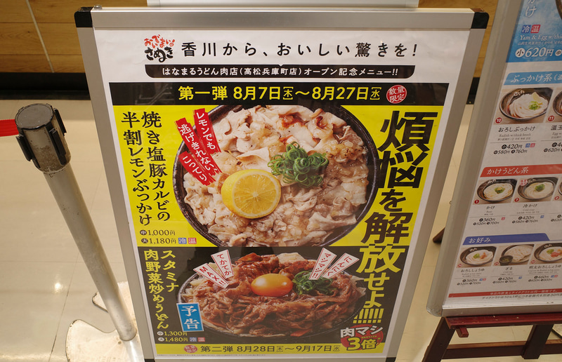 注文カウンター手前の看板で「焼き塩豚カルビの半割レモンぶっかけ(温・冷)」と、後日登場予定の「スタミナ肉野菜炒めうどん(温・冷)」をアピール!