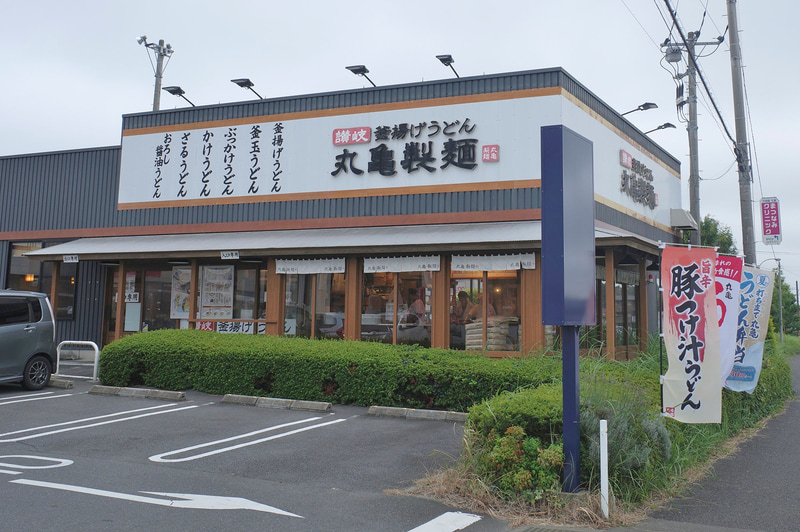 とあるロードサイド店舗では歩道脇の幟で「旨辛 豚つけ汁うどん(温泉玉子付き)」をアピール！