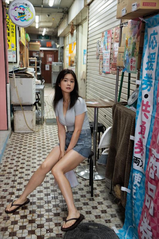 沖縄・名護市の街中での探索風景。スタイルの良さが一目瞭然の私服ショットですが、この時に買い込んだ“お土産”が、この後、思いがけない大胆ショットへとつながります　『真田まことファースト写真集 スペルバウンド 』（徳間書店）／ 撮影：野澤亘伸