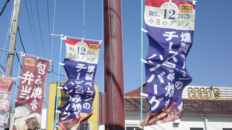 大通り沿いには「今月のグルメ～12月～」の「燻製ベーコンと舞茸の包み焼きハンバーグ～トマトと5種チーズのソース～」を幟でアピール!