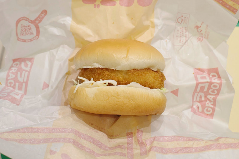 「グラコロ」は、コロッケソースの酸味があと引く具だくさんなグラタンコロッケ、千切りキャベツ、タマゴソースを分厚いバンズで挟み込んで今年も激ウマ!