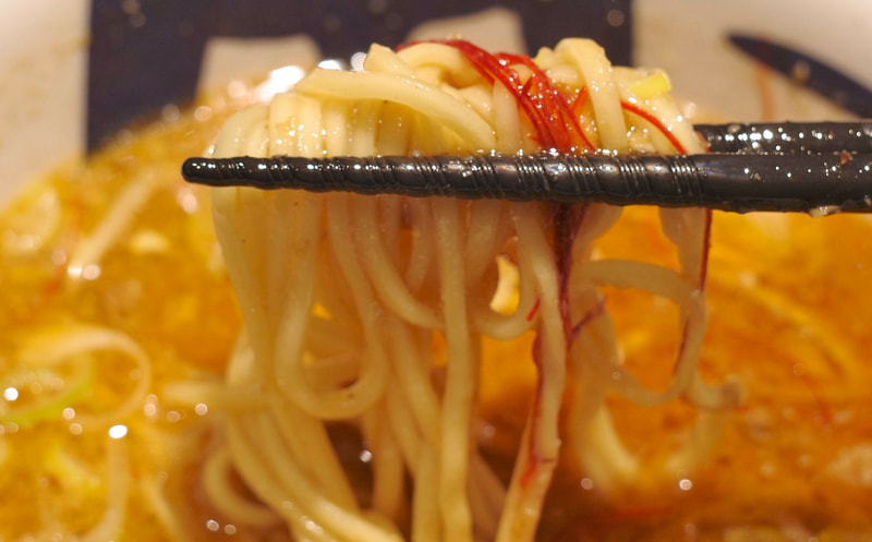 スープの味がよく絡んだ麺に辛味を帯びた糸唐辛子をプラスしてFINISH!