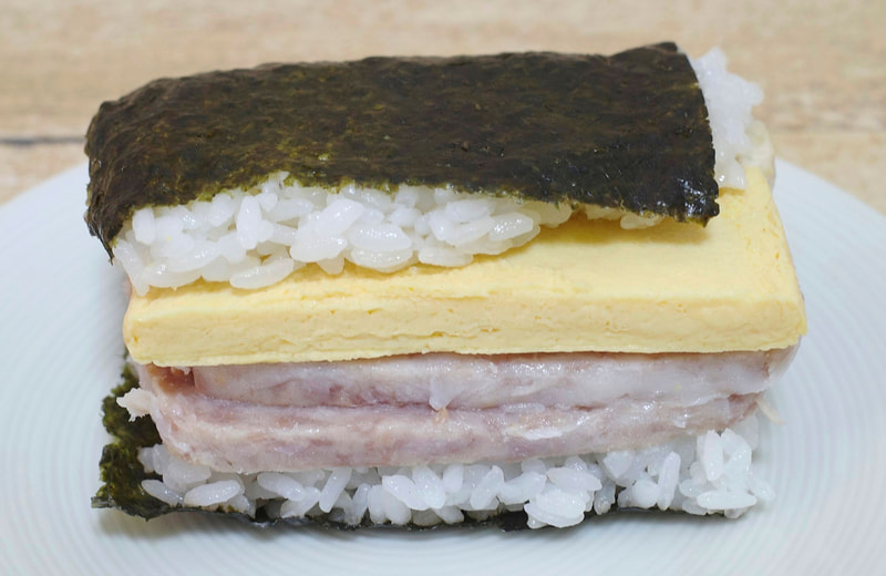「盛りすぎ!具!おにぎり ポーク玉子(シーチキンマヨネーズ)」を正面から見ると、玉子焼きとポークランチョン2枚を重ねた絵力の強さに感激!