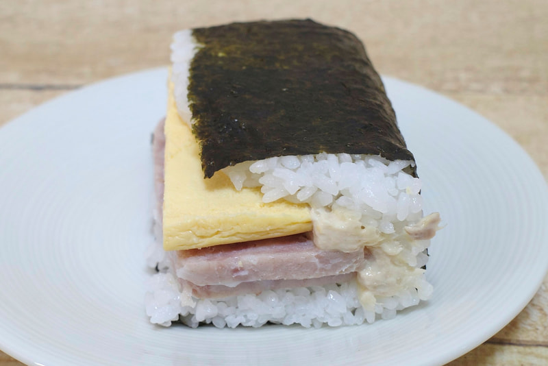 「盛りすぎ!具!おにぎり ポーク玉子(シーチキンマヨネーズ)」を横から見ると、シーチキンマヨネーズもガッツリIN!