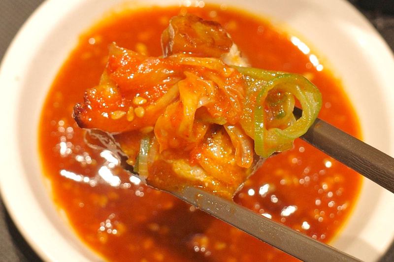 塩豚カルビにコチュジャンたれ、青ねぎ、キムチ、にんにくを添えることでご飯との相性の良さが大きくレベルアップ!